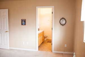 Interior space featuring light tile patterned floors, baseboards, and light colored carpet