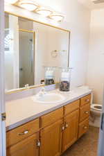 Full bathroom featuring a stall shower, visible vents, toilet, tile patterned floors, and vanity