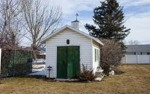 View of outdoor structure with an outbuilding and fence