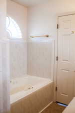 Full bath with tiled tub and tile patterned floors