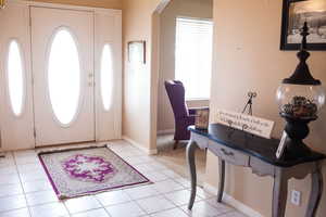 Entryway with arched walkways and light tile patterned floors