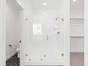Bathroom featuring a stall shower, a walk in closet, and recessed lighting