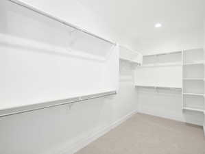 Walk in closet with light colored carpet