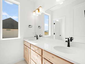 Full bath featuring double vanity and baseboards