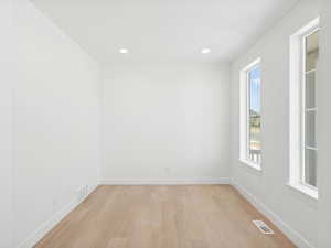 Spare room with light wood finished floors, healthy amount of natural light, and recessed lighting