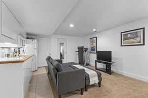 Living room featuring light tile patterned floors, baseboards, and recessed lighting