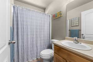 Full bath featuring toilet, tile patterned flooring, a shower with shower curtain, and vanity