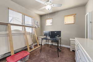 Office space featuring carpet, a textured ceiling, baseboards, and a ceiling fan