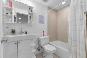 Full bath featuring shower / bath combination with curtain, visible vents, toilet, vanity, and tile patterned floors