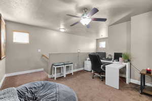 Office space with baseboards, a textured ceiling, and light colored carpet