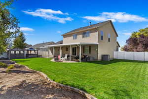 Rear view of property with an outbuilding, a patio, a fenced backyard, a yard, and a shed