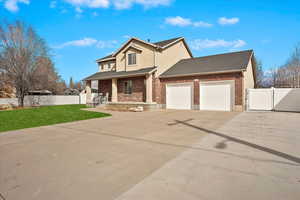 View of front of property featuring a garage, a gate, driveway, and fence