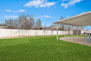 View of yard with a patio area, a shed, a fenced backyard, and an outdoor structure