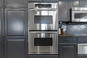 Kitchen with appliances with stainless steel finishes and backsplash