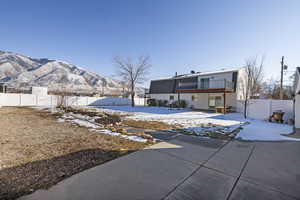 Back of house featuring a patio, a fenced backyard, and a mountain view