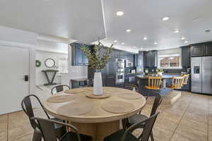 Dining area with light tile patterned floors, visible vents, a textured ceiling, and recessed lighting