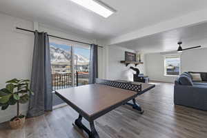 Playroom featuring a ceiling fan, brick wall, and wood finished floors