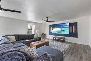 Living area featuring ceiling fan, baseboards, and wood finished floors