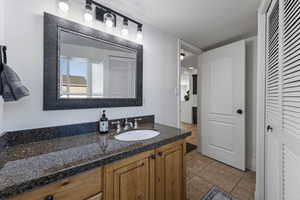Bathroom featuring vanity, a closet, and tile patterned floors