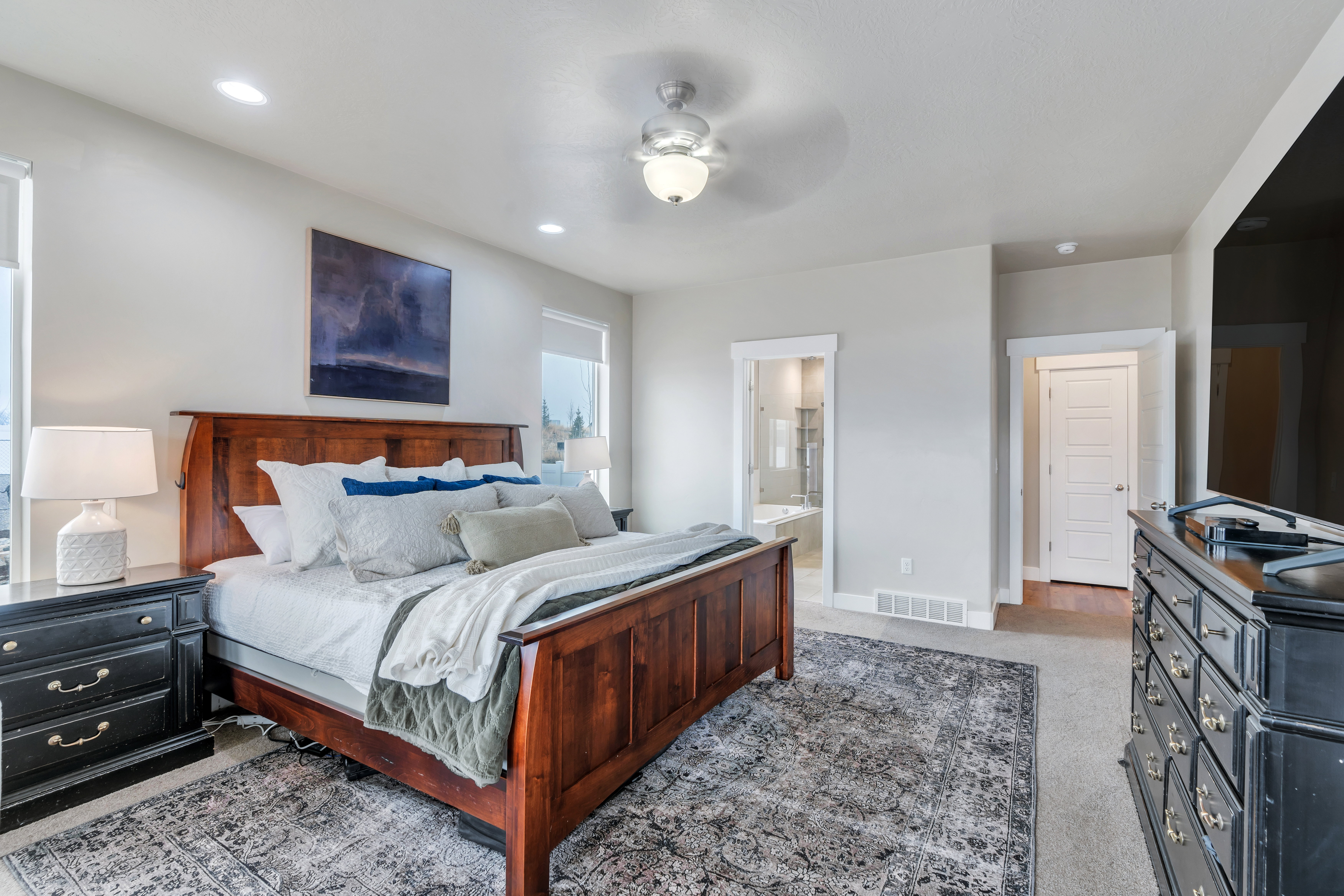 Carpeted bedroom featuring baseboards, visible vents, ceiling fan, ensuite bathroom, and recessed lighting