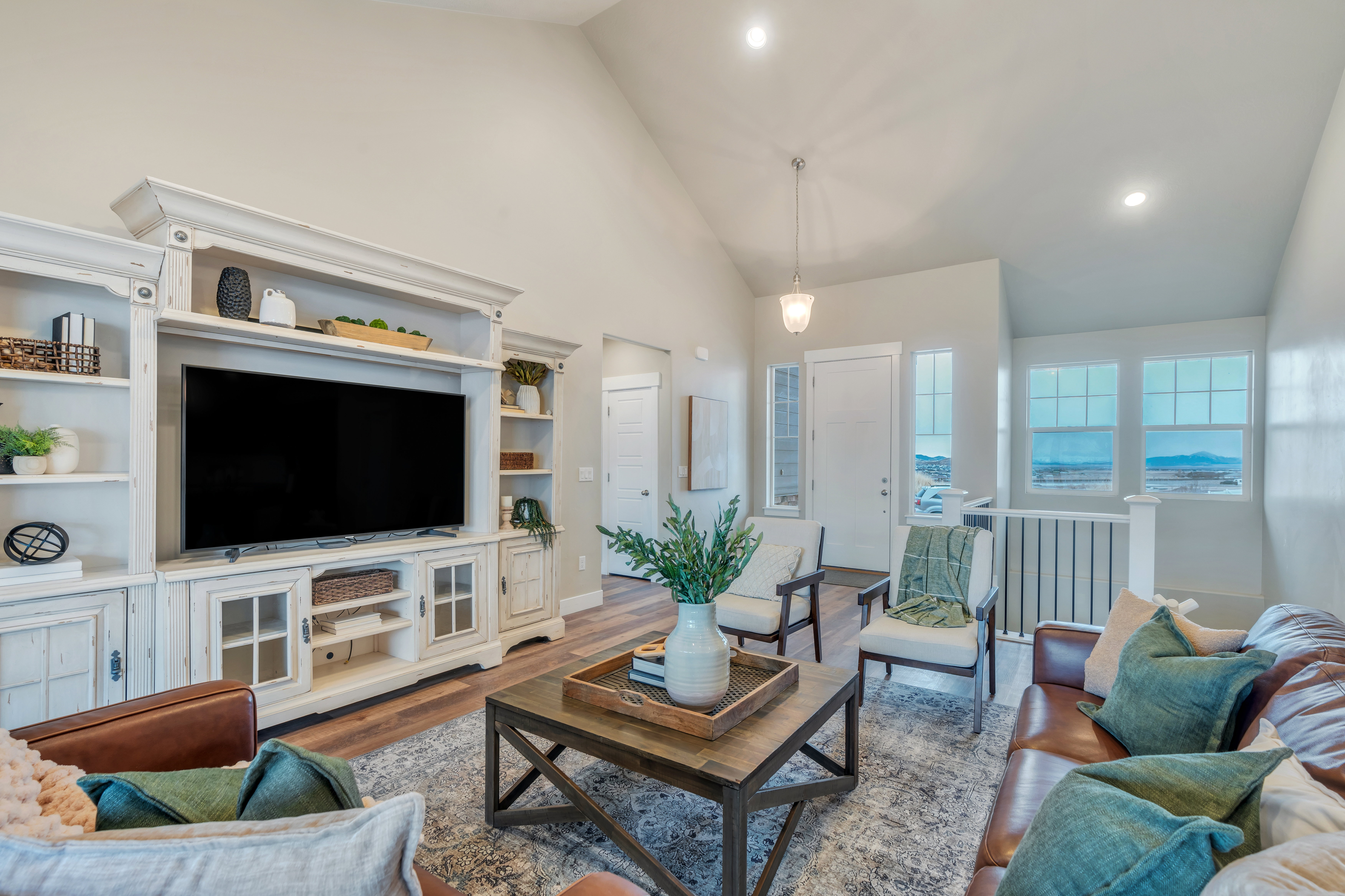 Living room featuring high vaulted ceiling, recessed lighting, baseboards, and wood finished floors