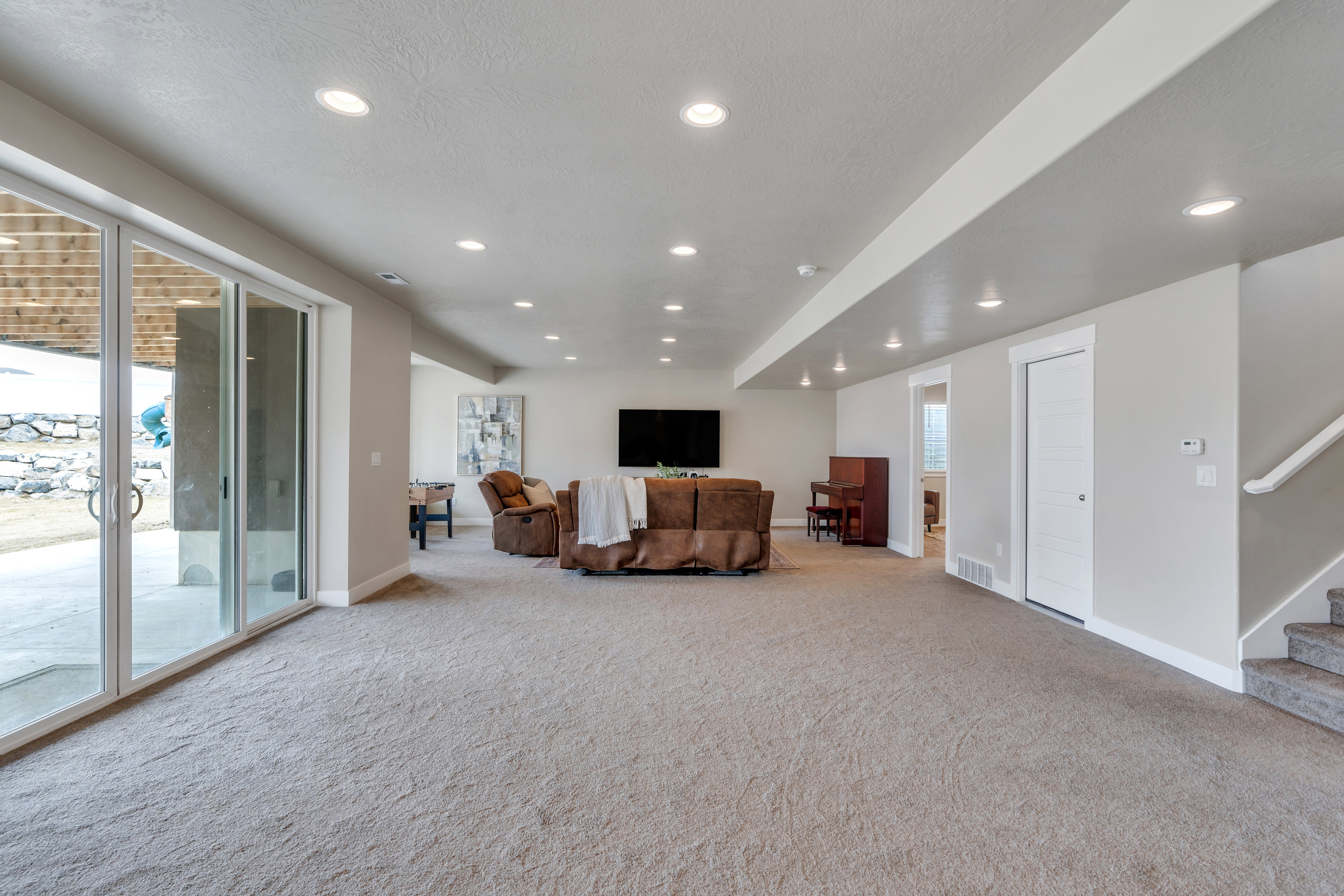 Living area featuring stairs, carpet, baseboards, and recessed lighting