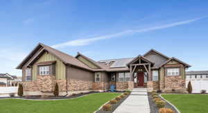 Craftsman inspired home with board and batten siding, roof mounted solar panels, stone siding, and roof with shingles