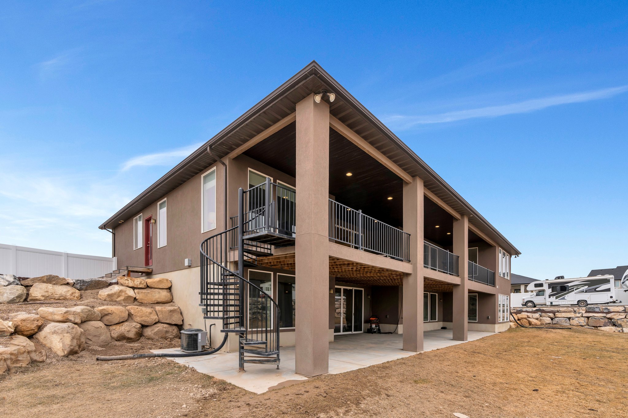 Back of property featuring a patio, central AC unit, stairway, and stucco siding