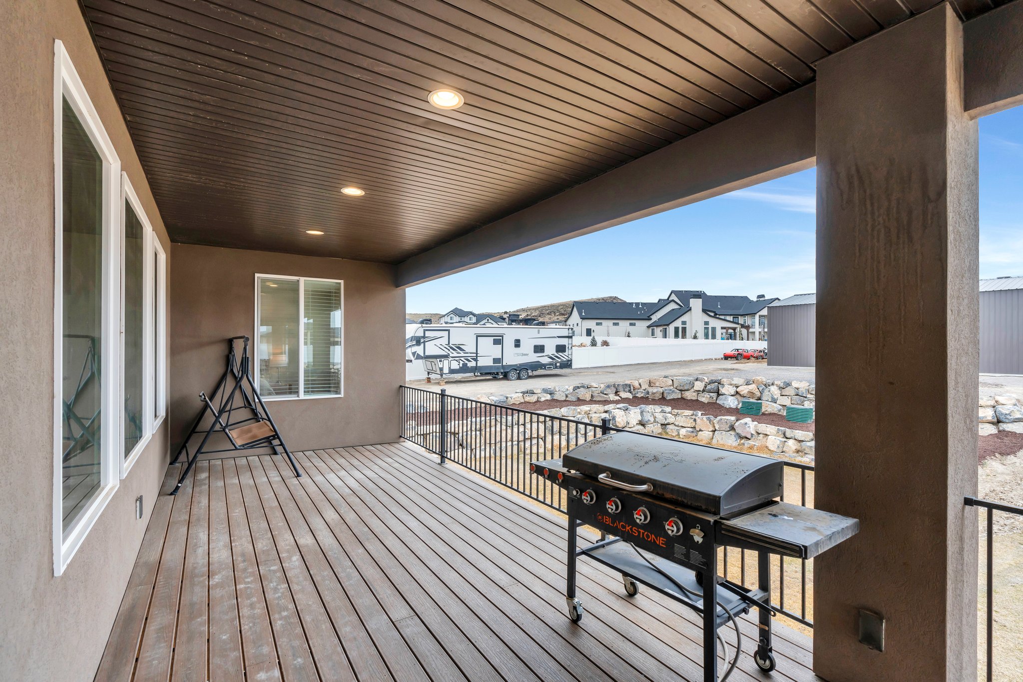 Wooden deck with a residential view and grilling area