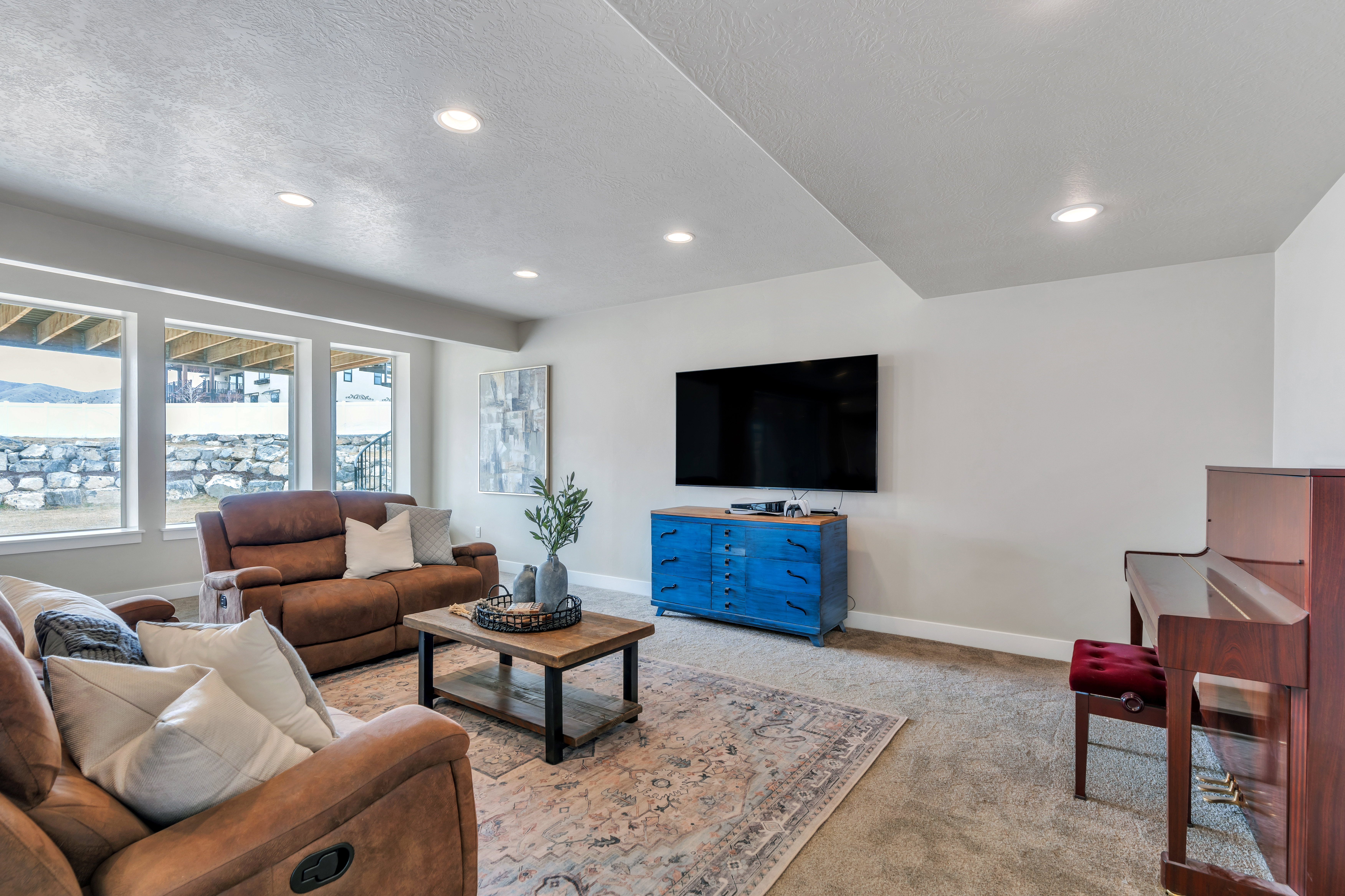 Living area featuring recessed lighting, light colored carpet, a textured ceiling, and baseboards