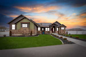 Craftsman inspired home featuring solar panels, board and batten siding, stone siding, and a mountain view