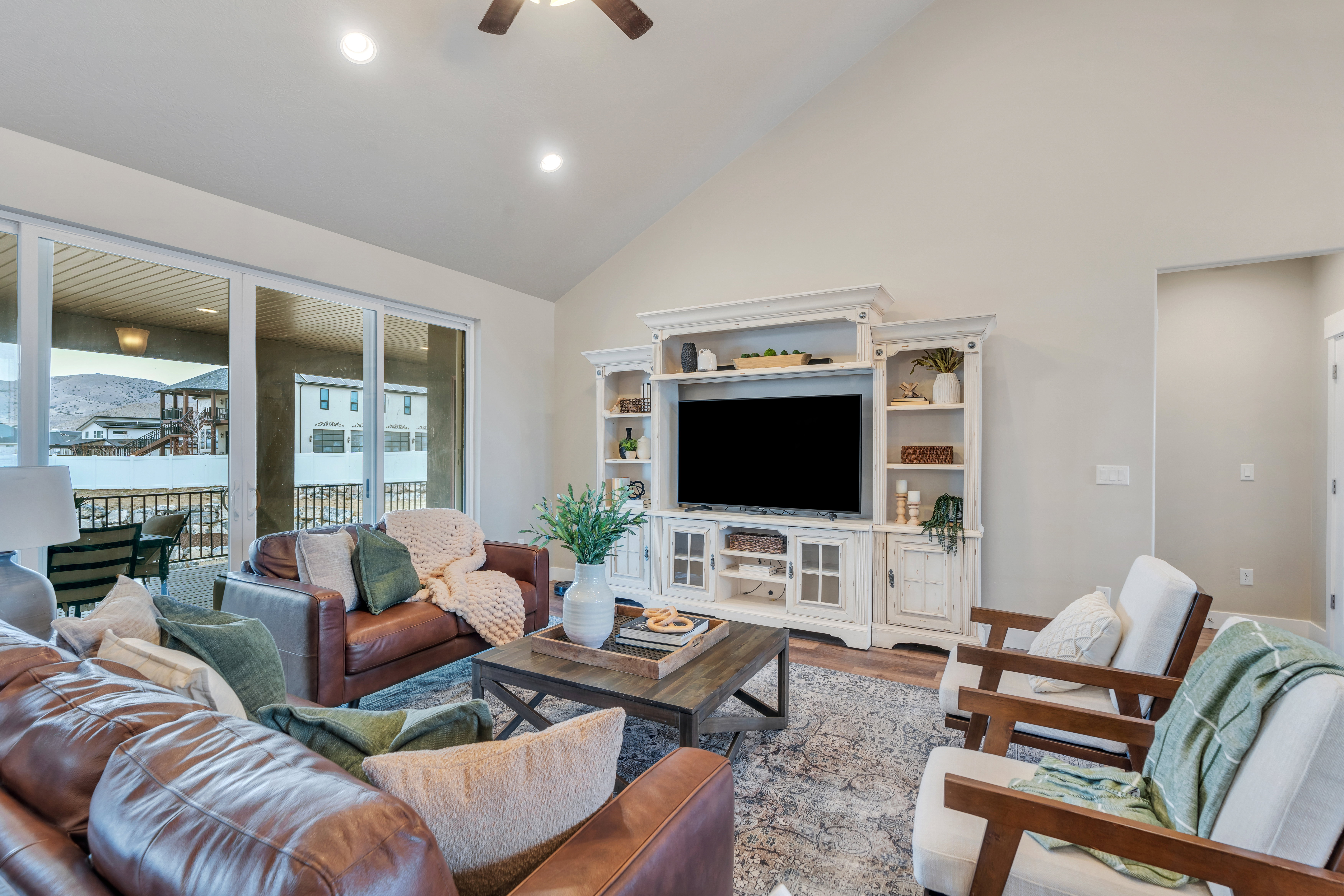 Living room with ceiling fan, high vaulted ceiling, wood finished floors, and recessed lighting