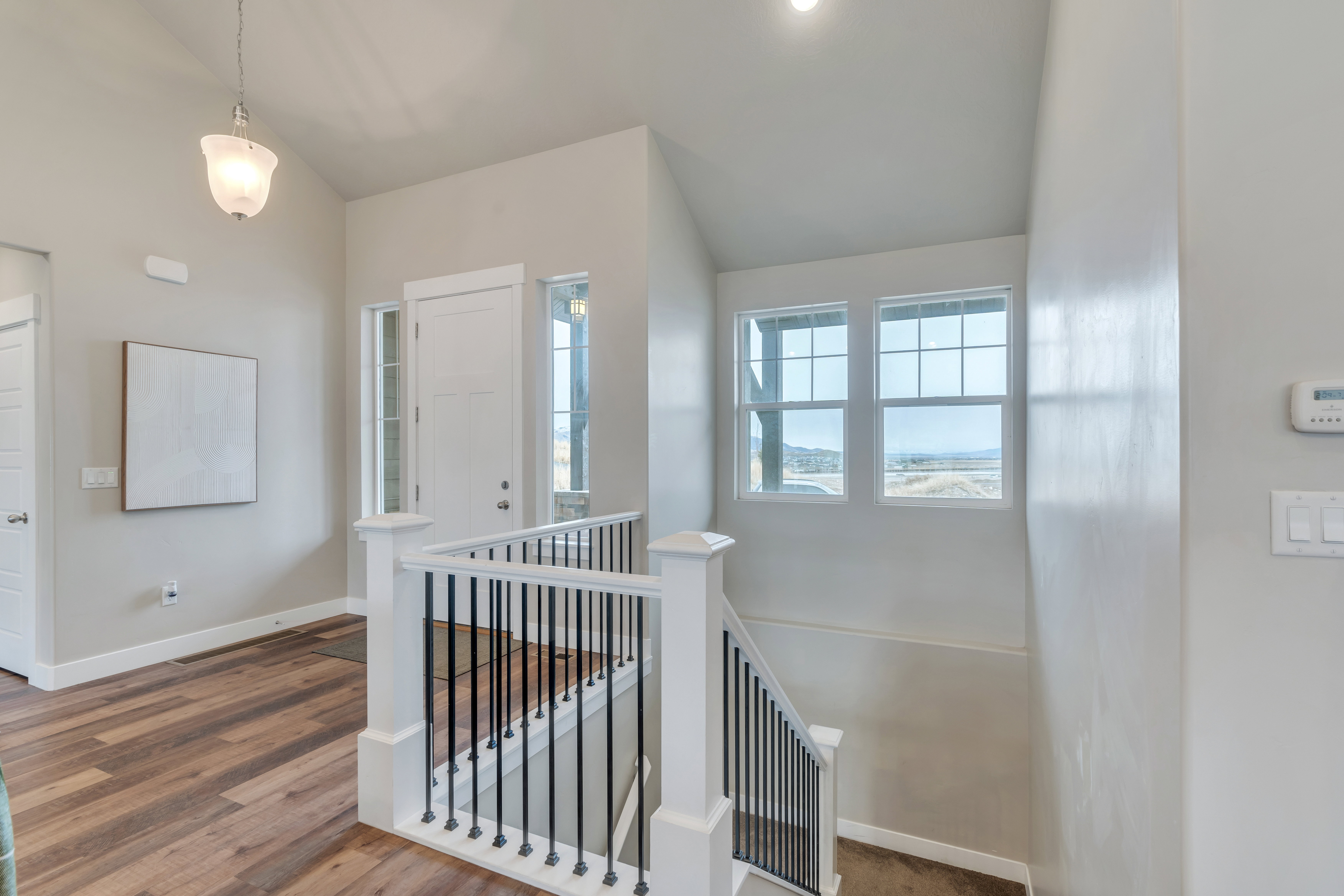 Interior space featuring baseboards, vaulted ceiling, and wood finished floors