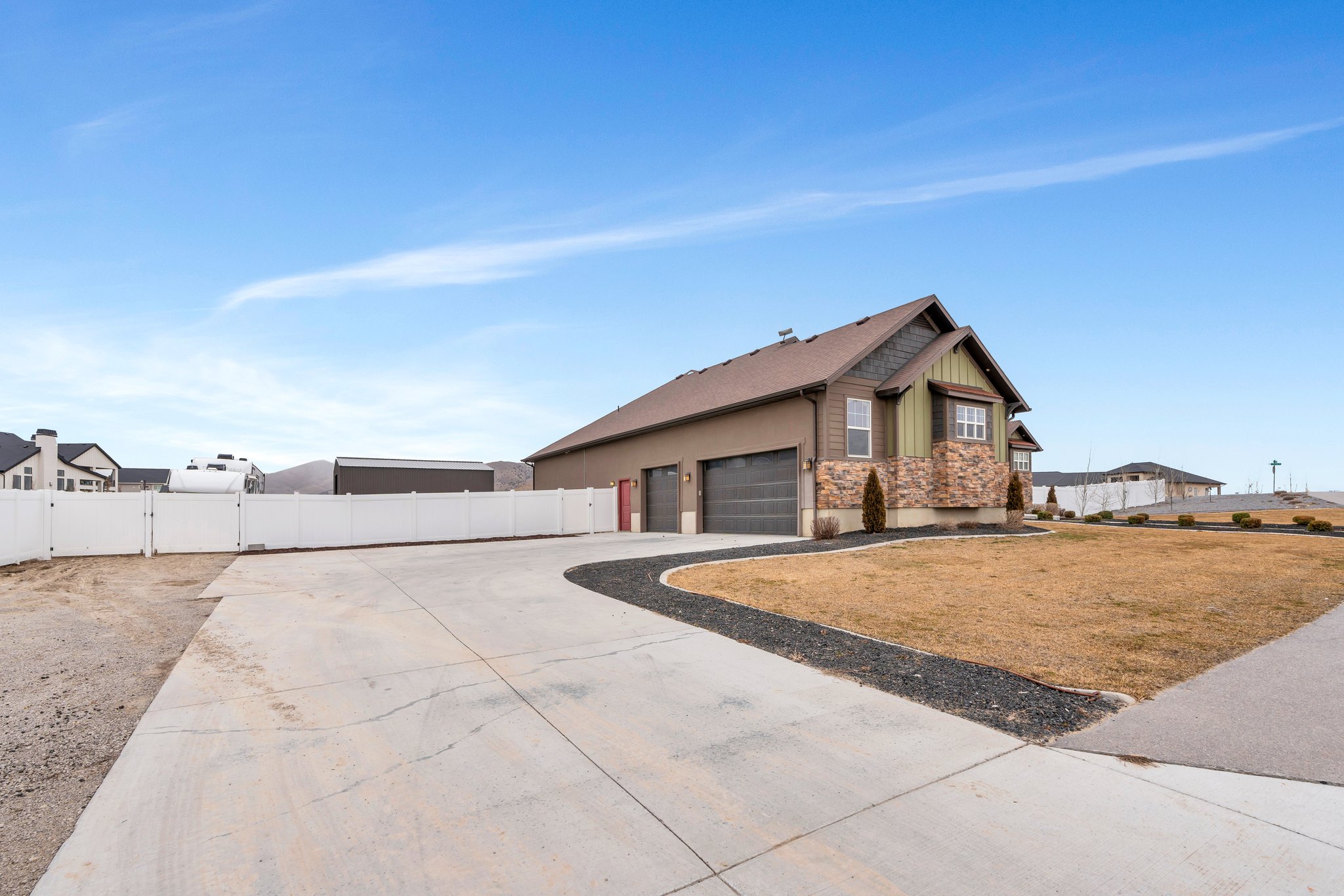 View of front of property featuring a garage, a gate, fence, and driveway