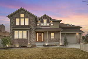 View of front of house featuring a garage, covered porch, concrete driveway,  lawn