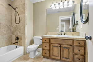 Bathroom featuring   shower combination, vanity, and toilet