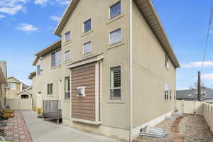 Back of house featuring a fenced backyard, a gate, a patio, and stucco siding