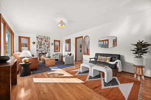 Living area featuring a large fireplace, wood finished floors, and baseboards