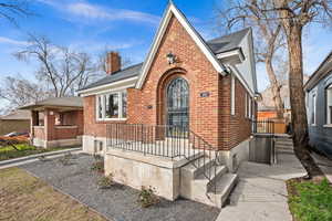 Tudor home featuring a chimney and brick siding