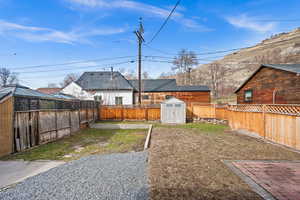 View of yard featuring a shed, a fenced backyard, and an outdoor structure