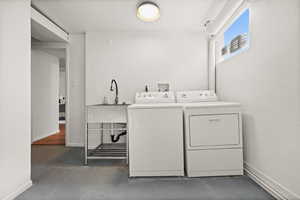 Clothes washing area with baseboards and washer and dryer