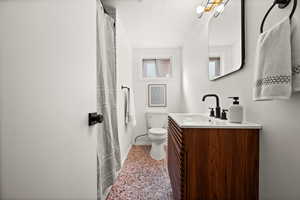 Full bathroom with tile patterned flooring, baseboards, vanity, and toilet