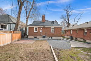 Back of property with a patio, a chimney, fence, central AC, and brick siding