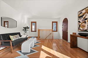 Living area featuring arched walkways, baseboards, and hardwood / wood-style flooring