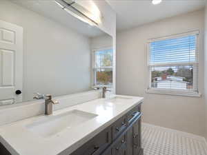 Bathroom with double vanity, baseboards, and a sink