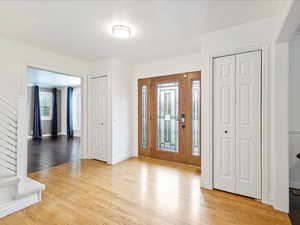 Foyer with stairs, baseboards, and wood finished floors