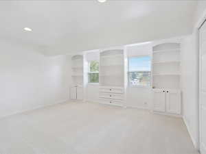 Spare room featuring baseboards, recessed lighting, and light colored carpet