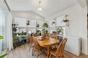 Dining room with lofted ceiling, light wood finished floors, a wealth of natural light, and recessed lighting