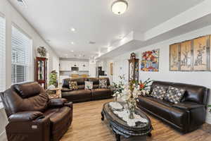 Living room featuring light wood-style floors, visible vents, and recessed lighting