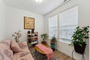 Living area featuring visible vents, baseboards, and wood finished floors